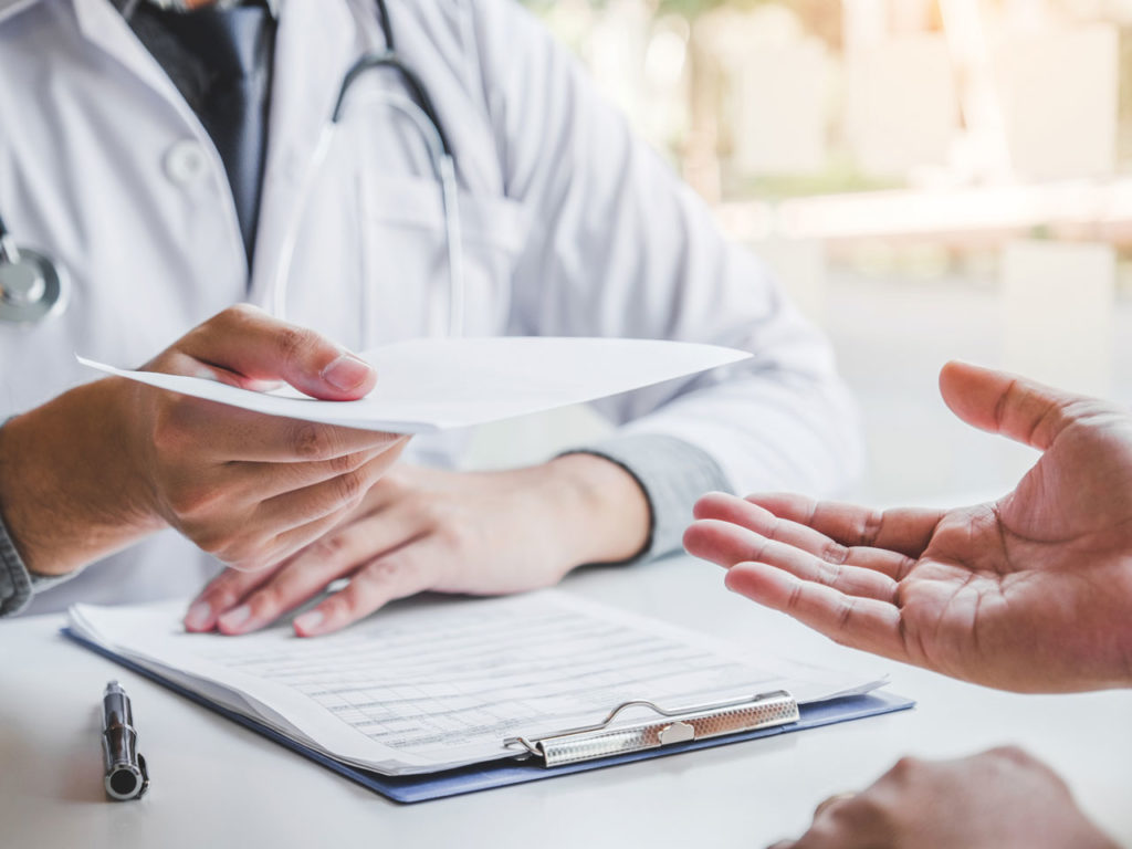 Doctor providing a prescription of a home phototherapy device to a patient.
