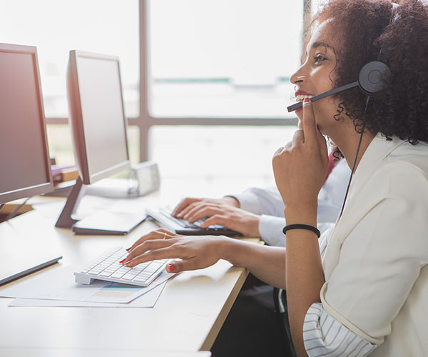 A female call center employee is talking to a customer who wants to apply for financing over the phone.